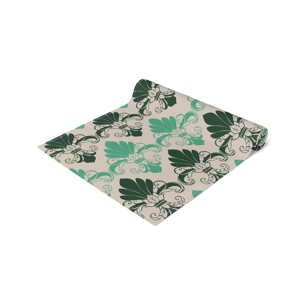Folded fabric with green leaf pattern on a beige background