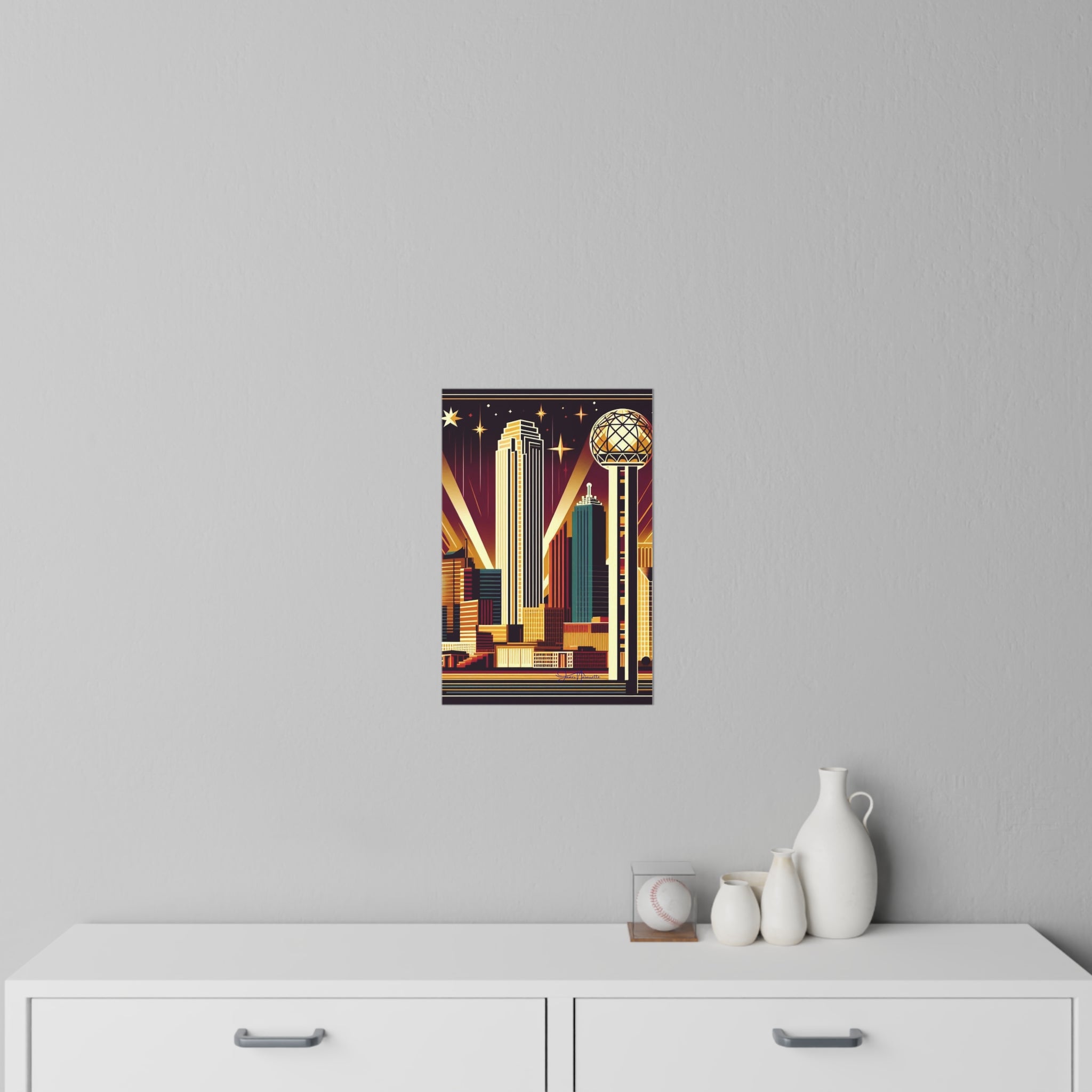 Art deco-style poster on a gray wall above a white cabinet with decorative items.
