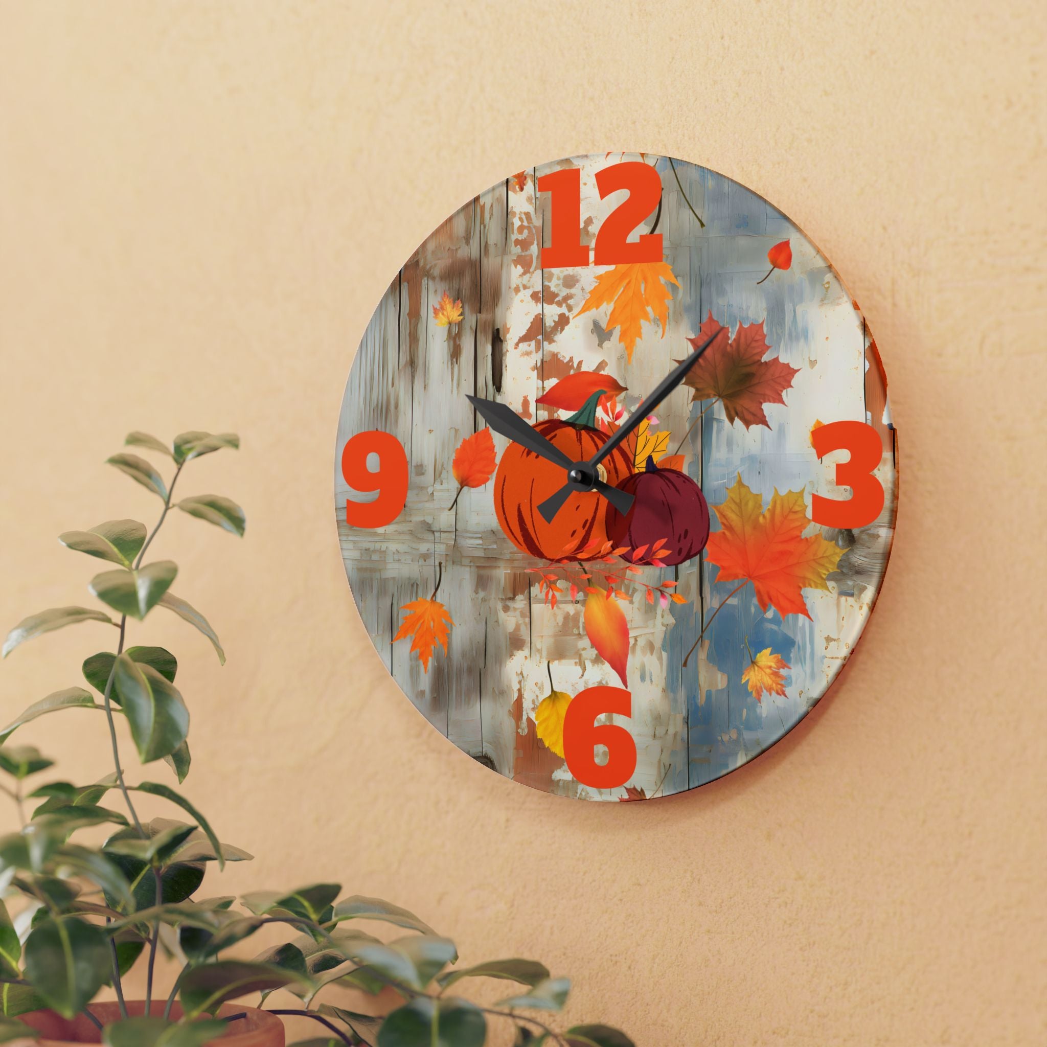 Decorative wall clock with autumn design featuring pumpkins and leaves on a beige wall.