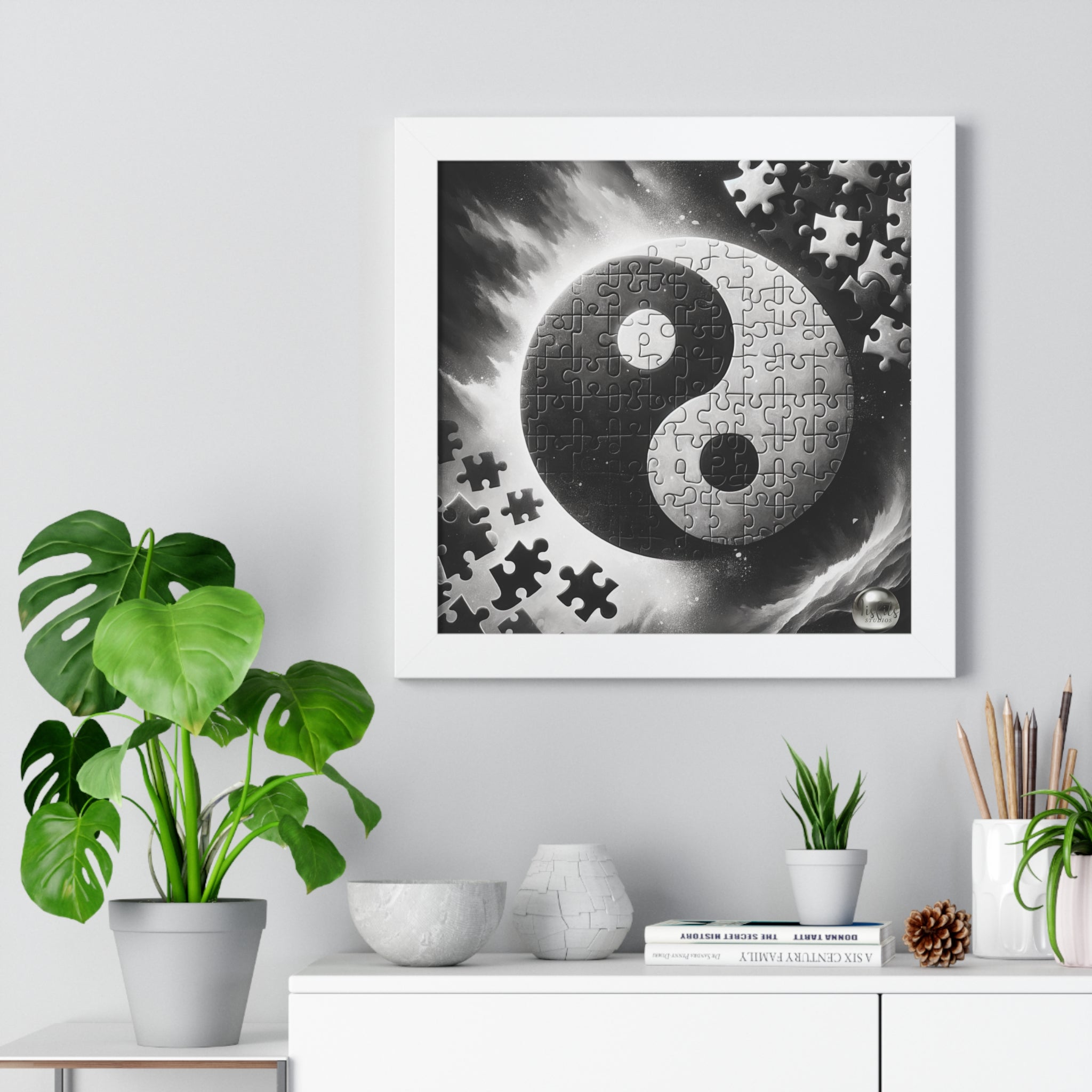 Framed artwork with a yin yang symbol made of puzzle pieces on a wall with decorative items below.