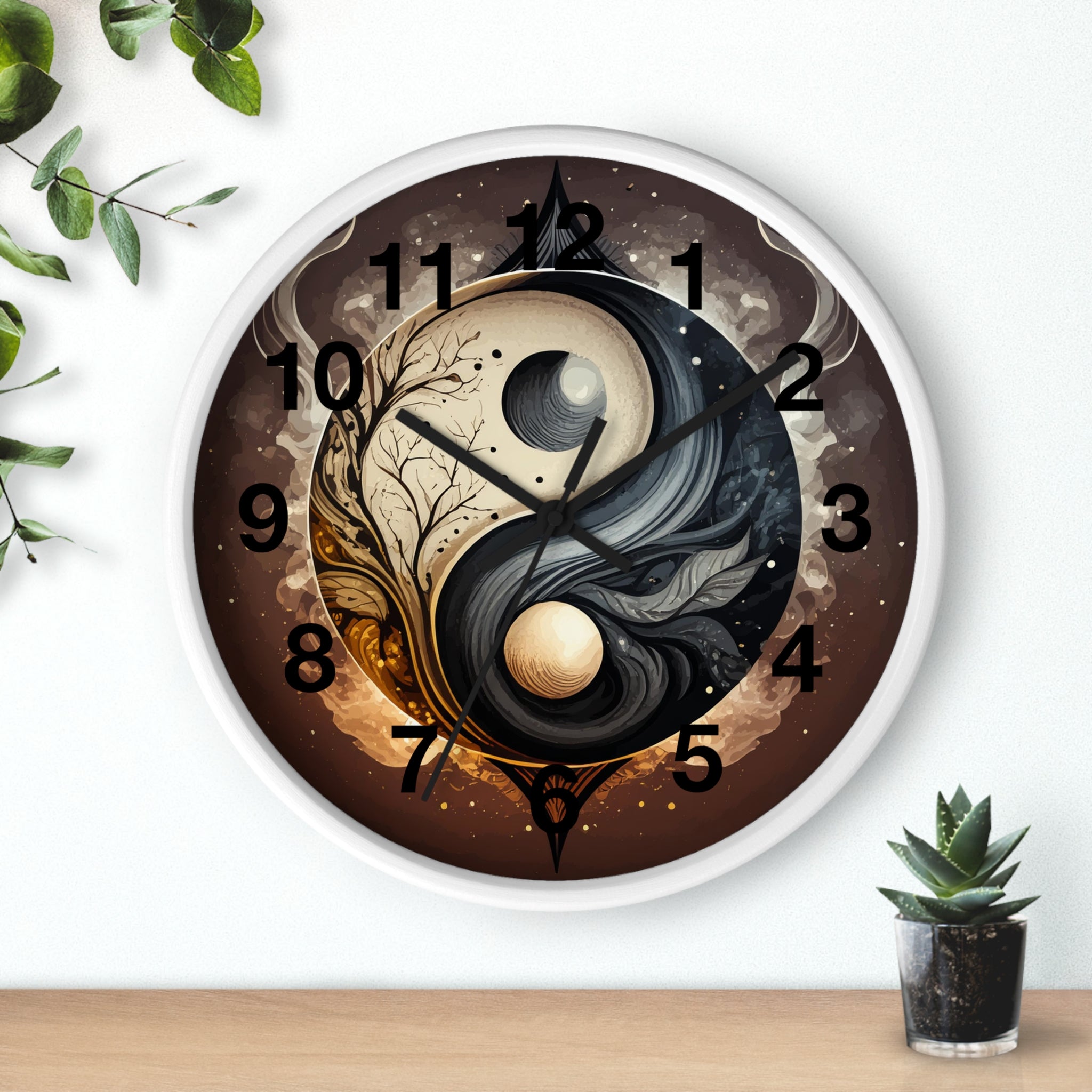Decorative wall clock with yin yang design on a white wall with a plant and small pot.