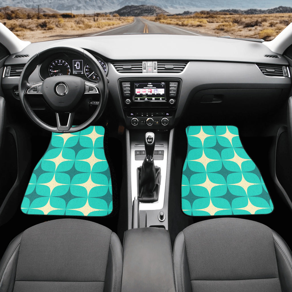 Car interior with teal and beige patterned floor mats on a desert road background