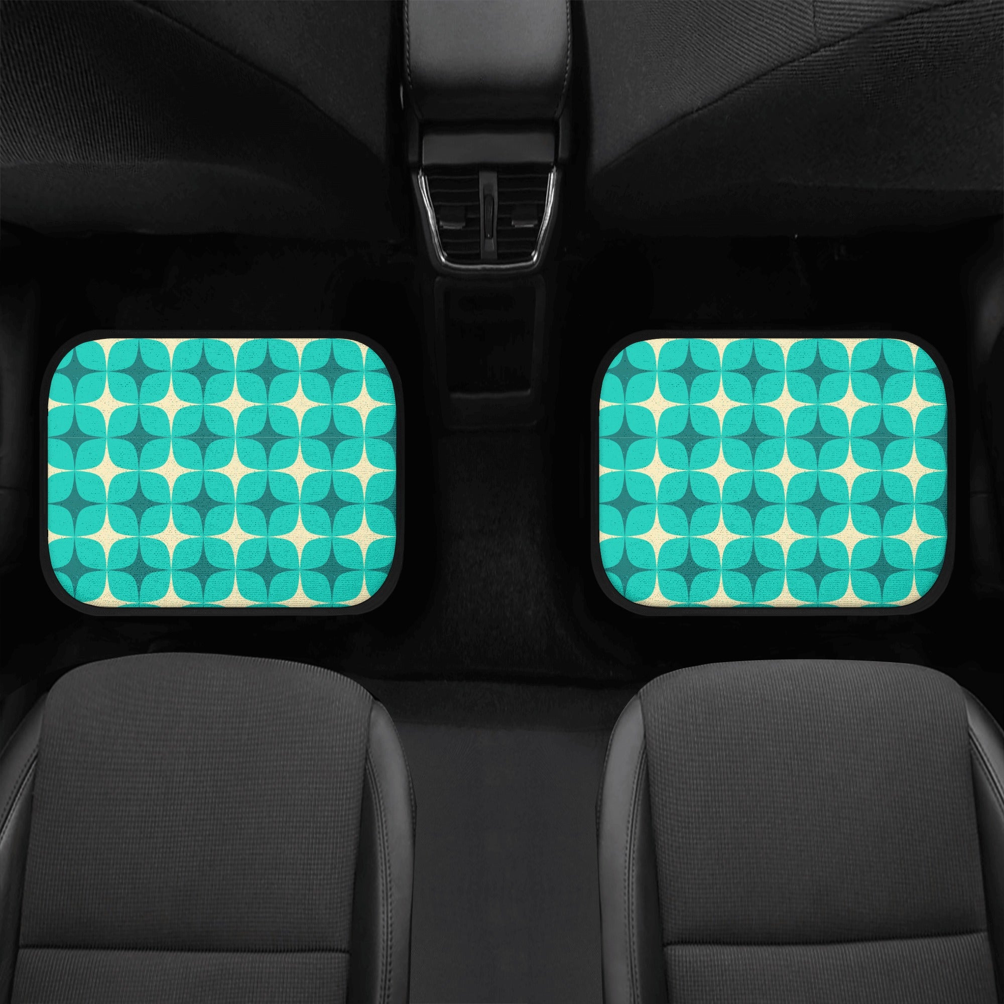 Two teal and white patterned car mats on a car seat.