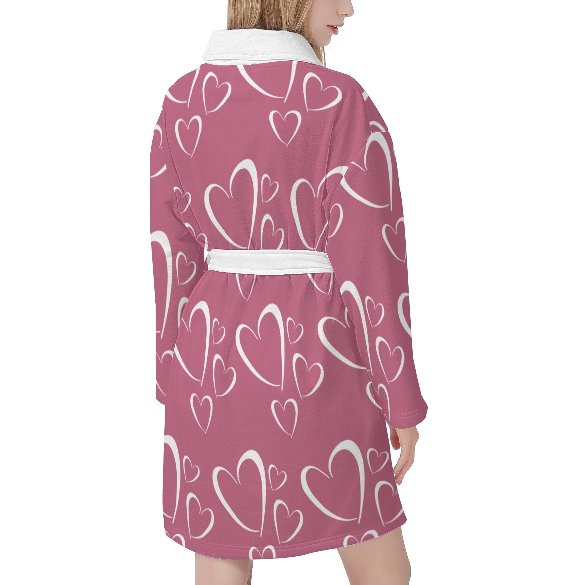 Pink robe with white heart patterns worn by a person on a white background