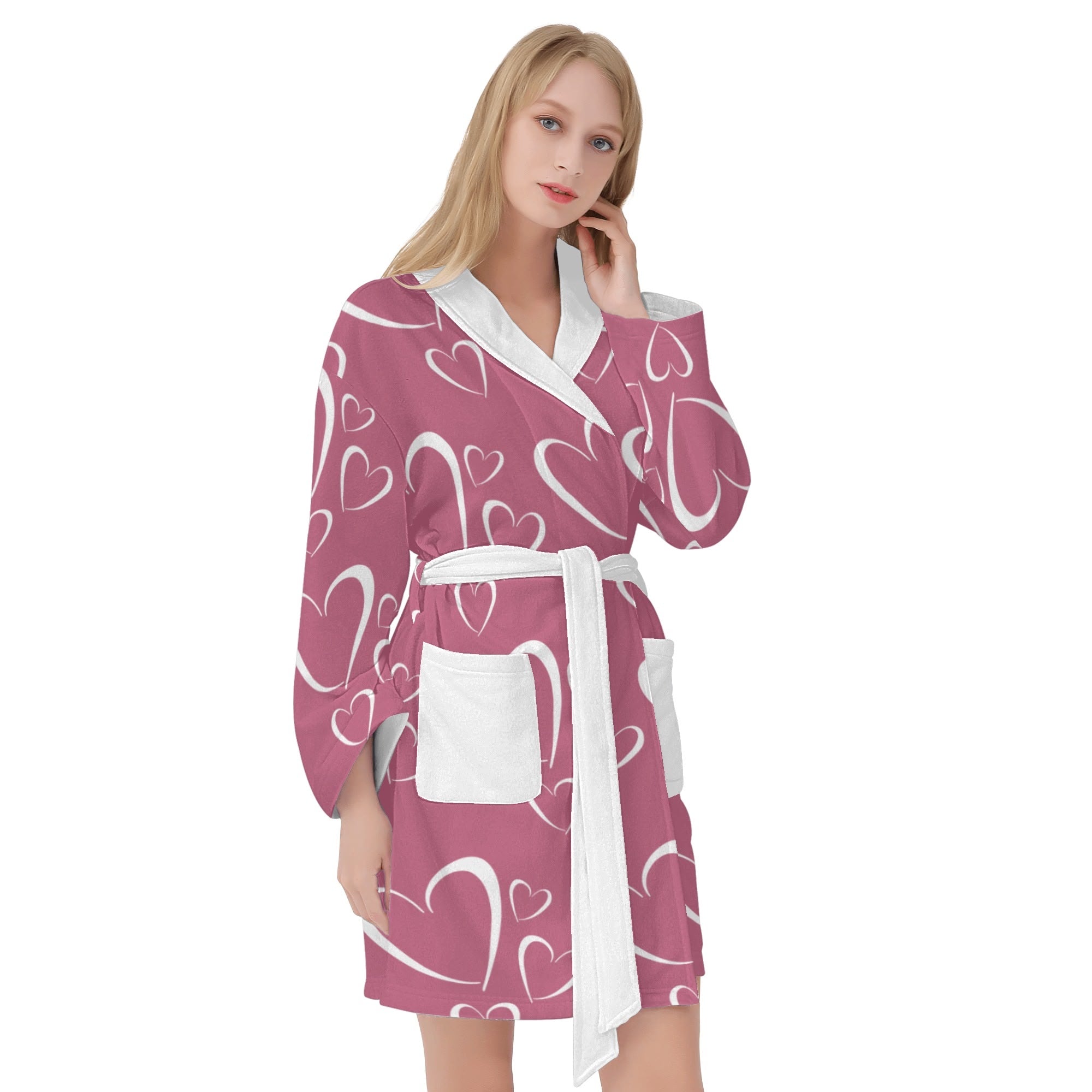 Woman wearing a pink robe with white heart patterns on a white background