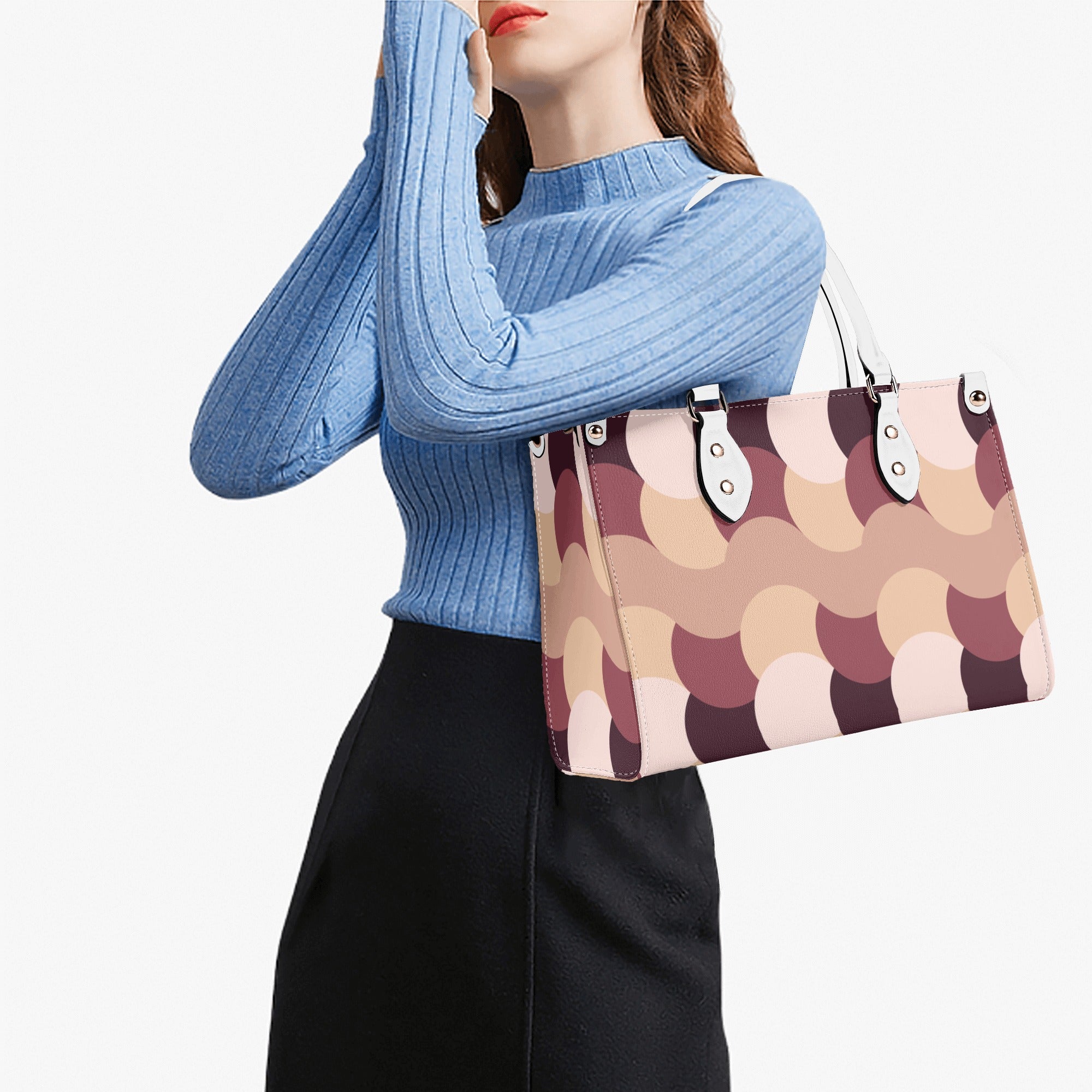 Woman holding a patterned handbag against a white background