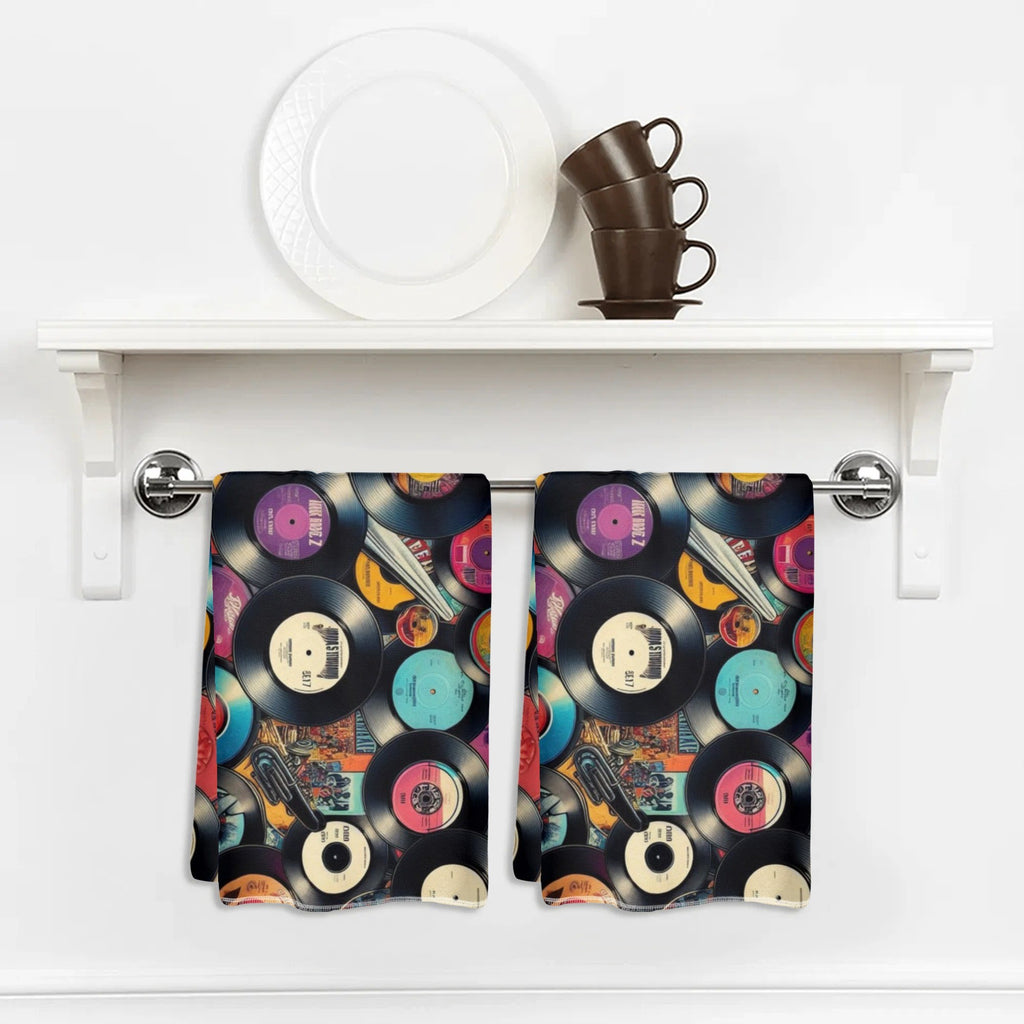 Kitchen towel with vinyl record design hanging on a white shelf.