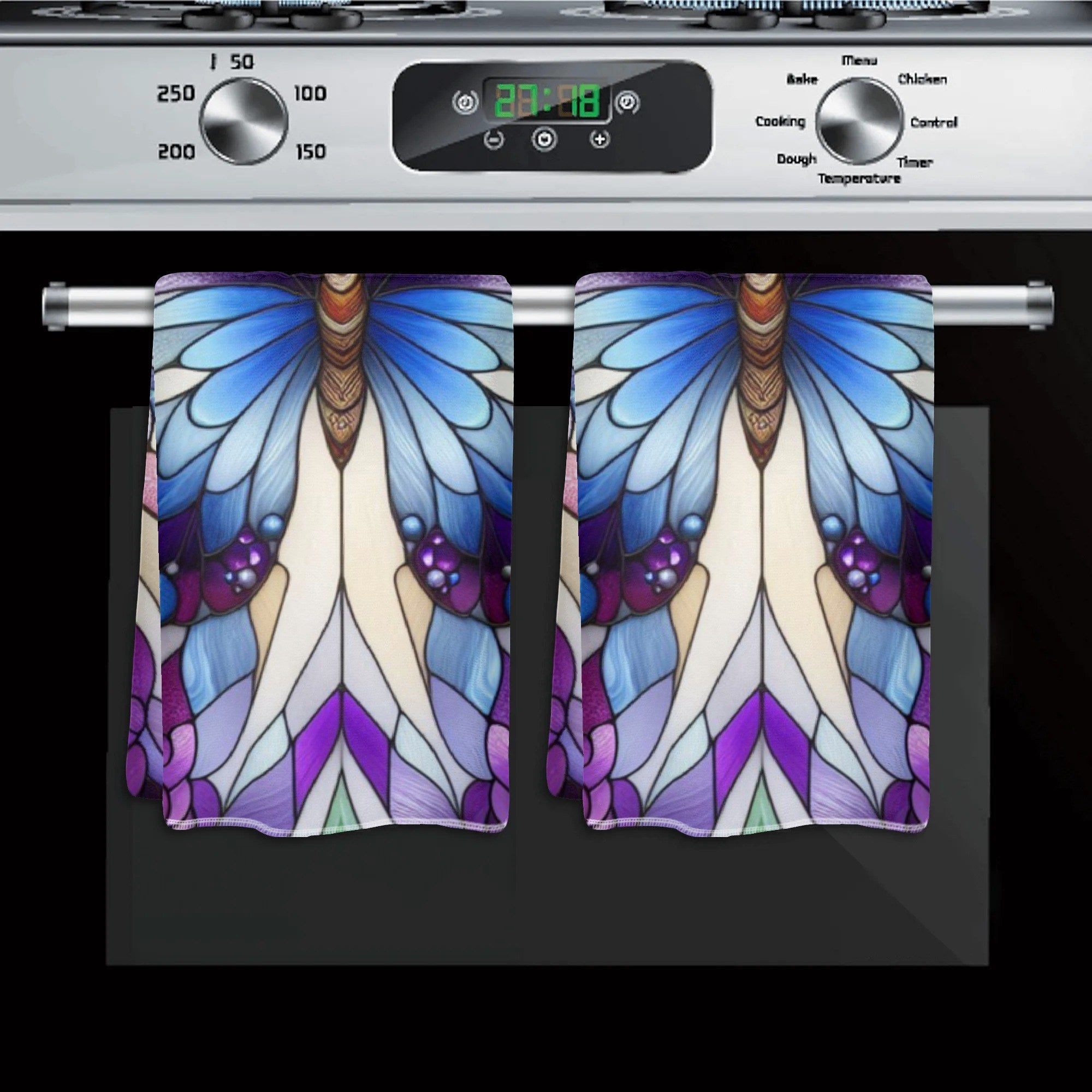 Decorative kitchen towel with butterfly design hanging on a stove handle