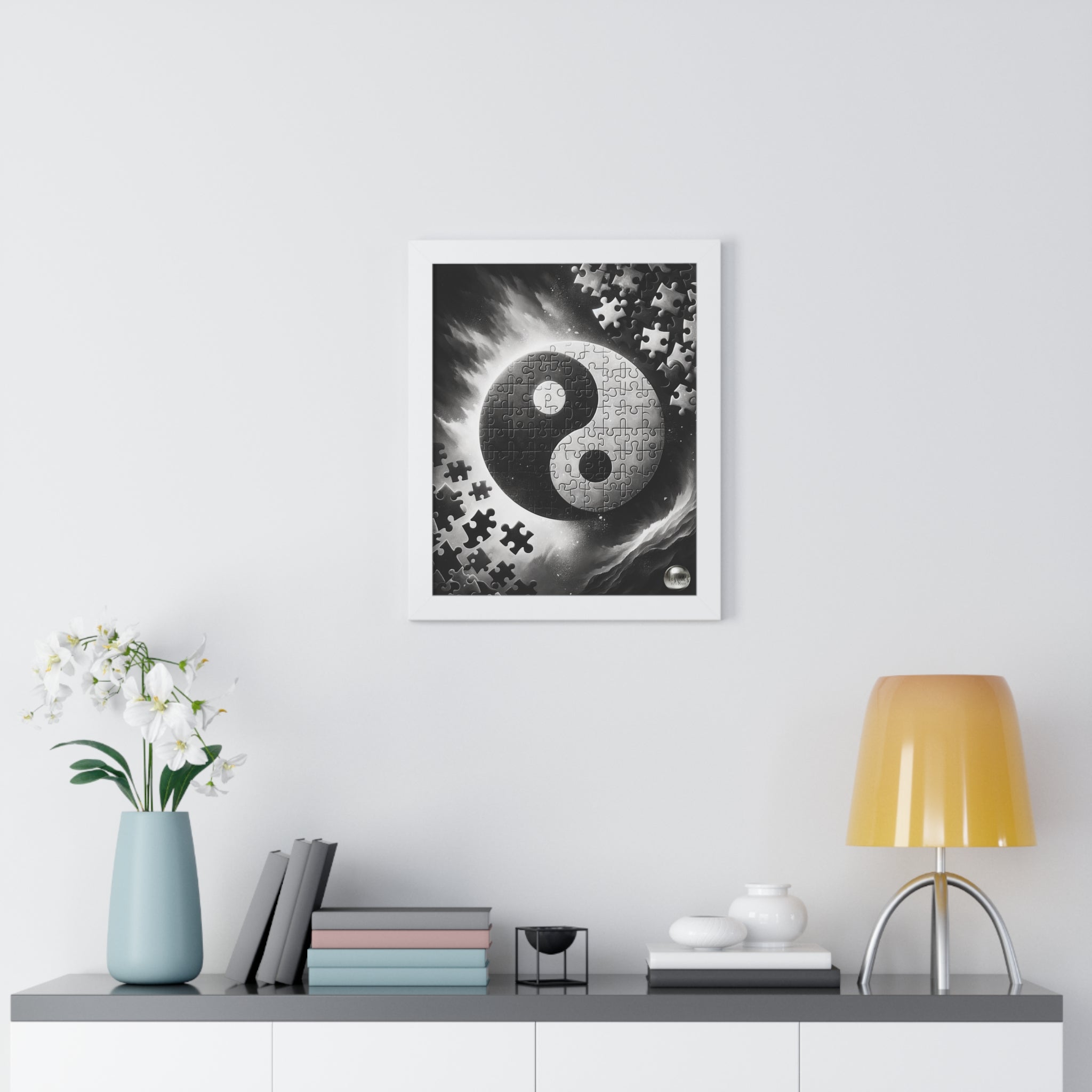 Framed artwork with a yin yang symbol on a wall above a shelf with decor items.