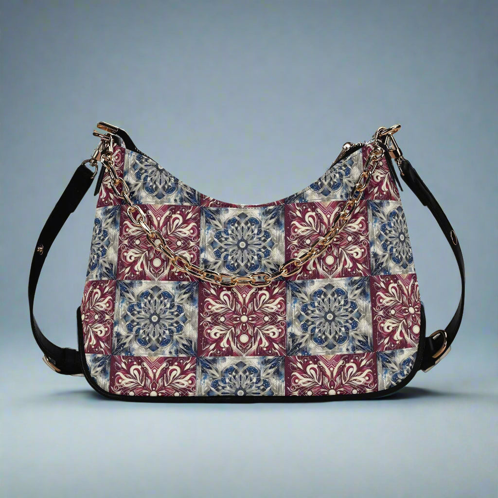 Multicolored patterned handbag with black straps on a white background