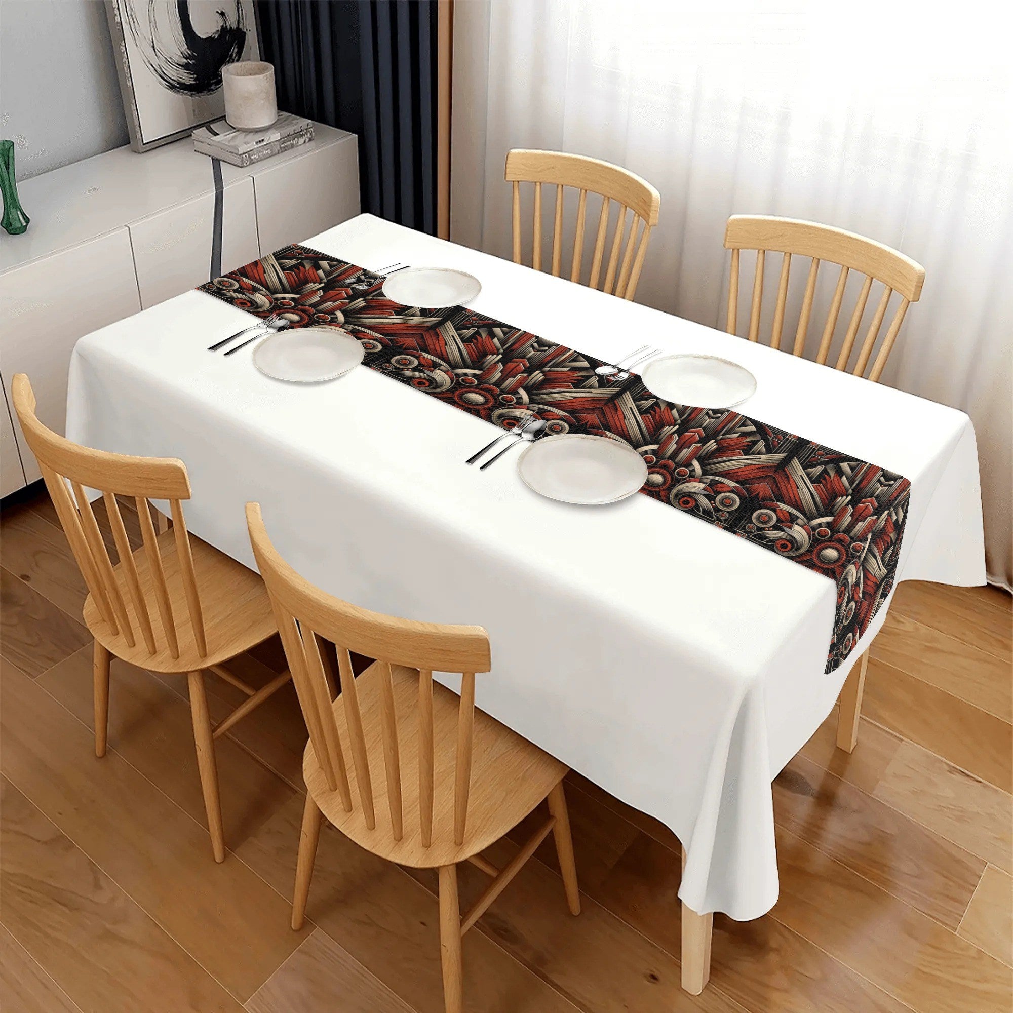Dining table with a patterned table runner, white tablecloth, and wooden chairs.