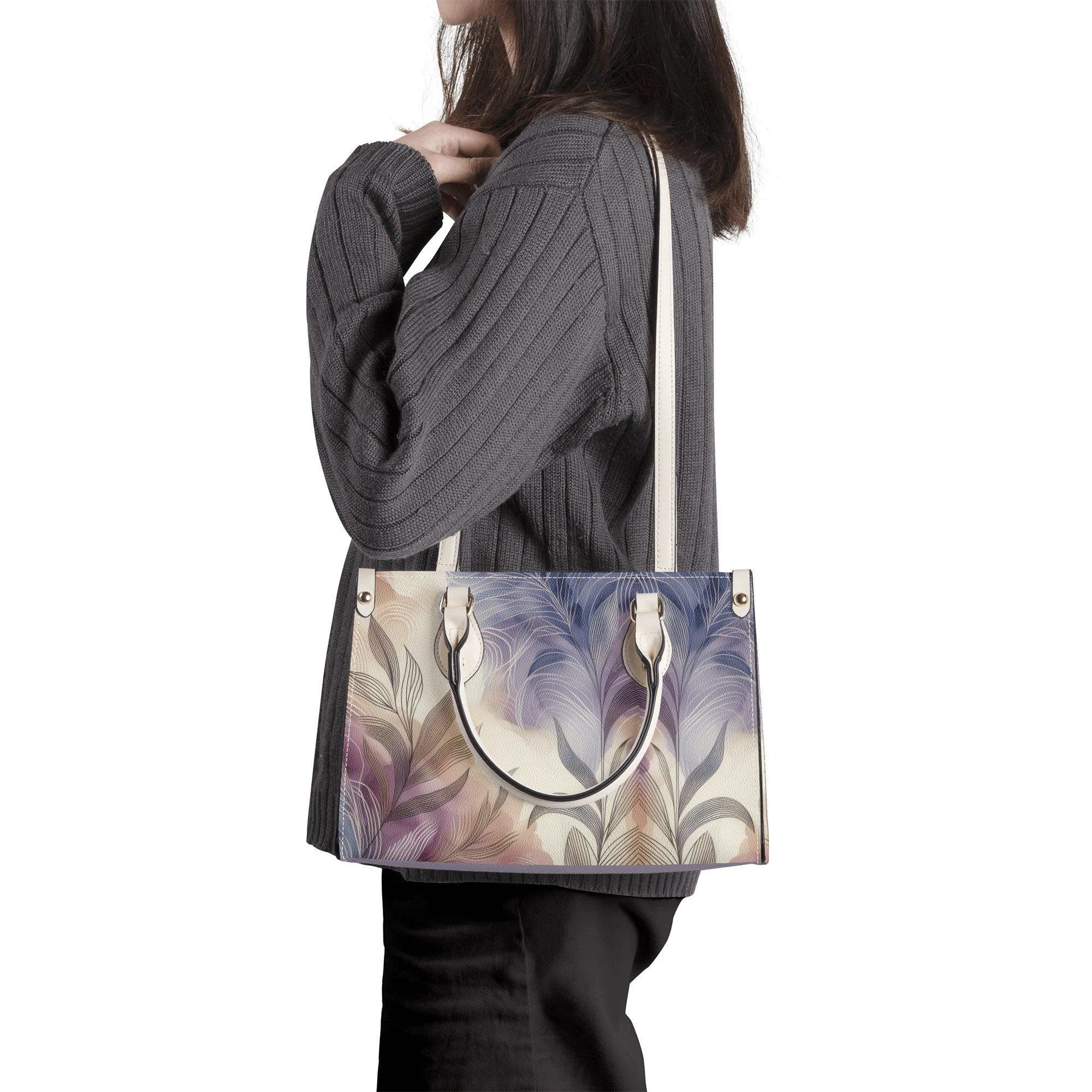 Person holding a handbag with a floral pattern on a white background