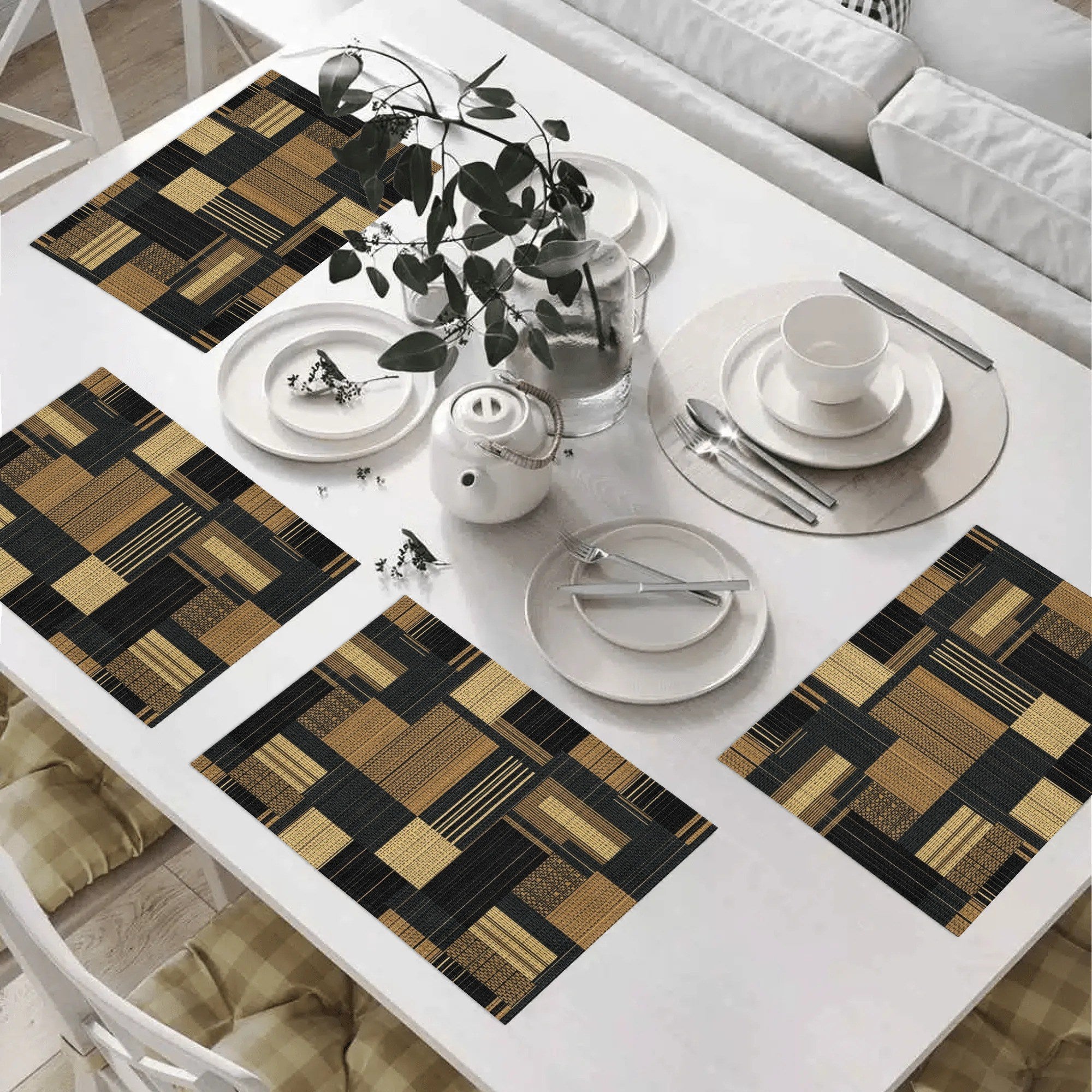 Dining table set with checkered placemats, white plates, and silverware in a living room.
