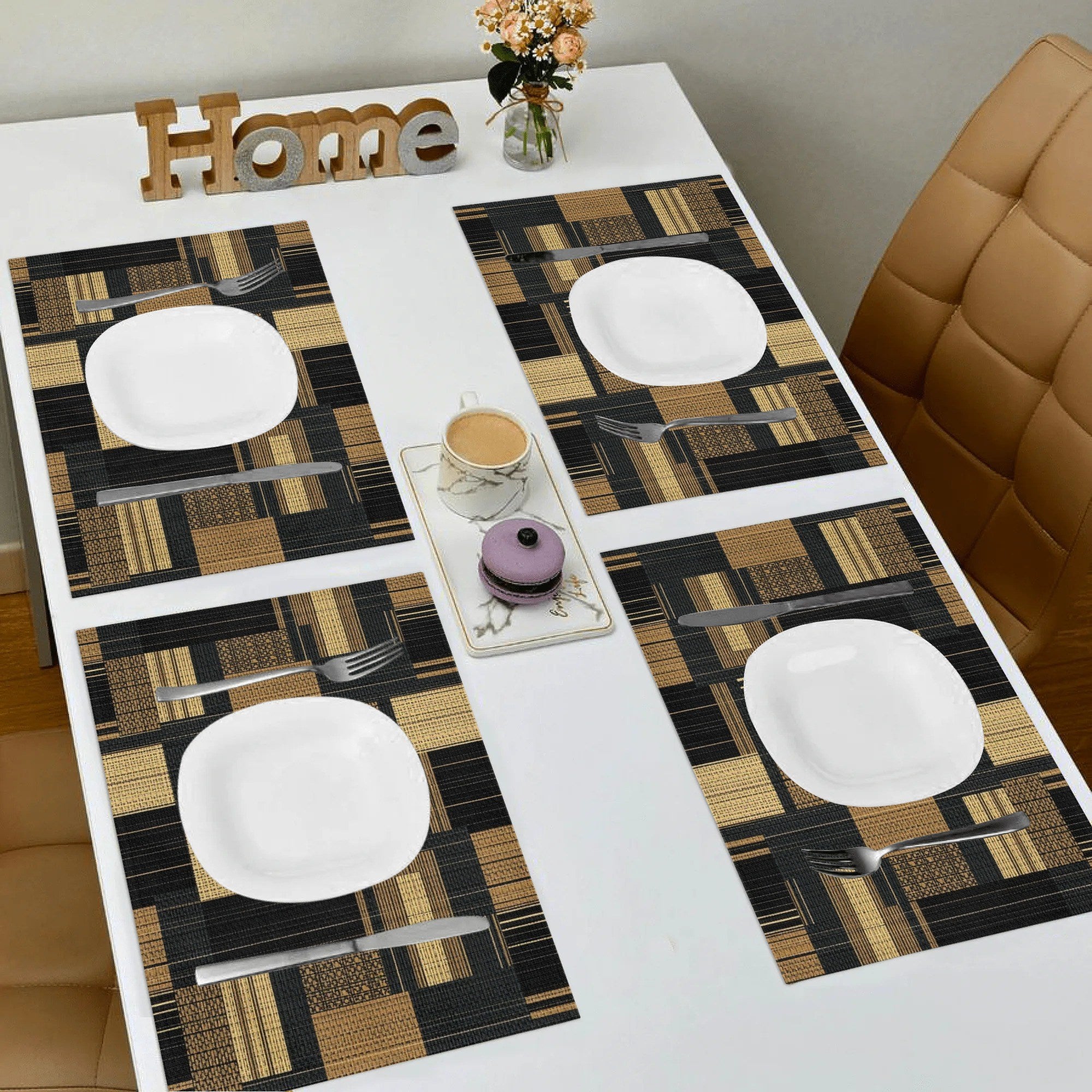 Table setting with a checkered table runner, plates, and cutlery on a white table.