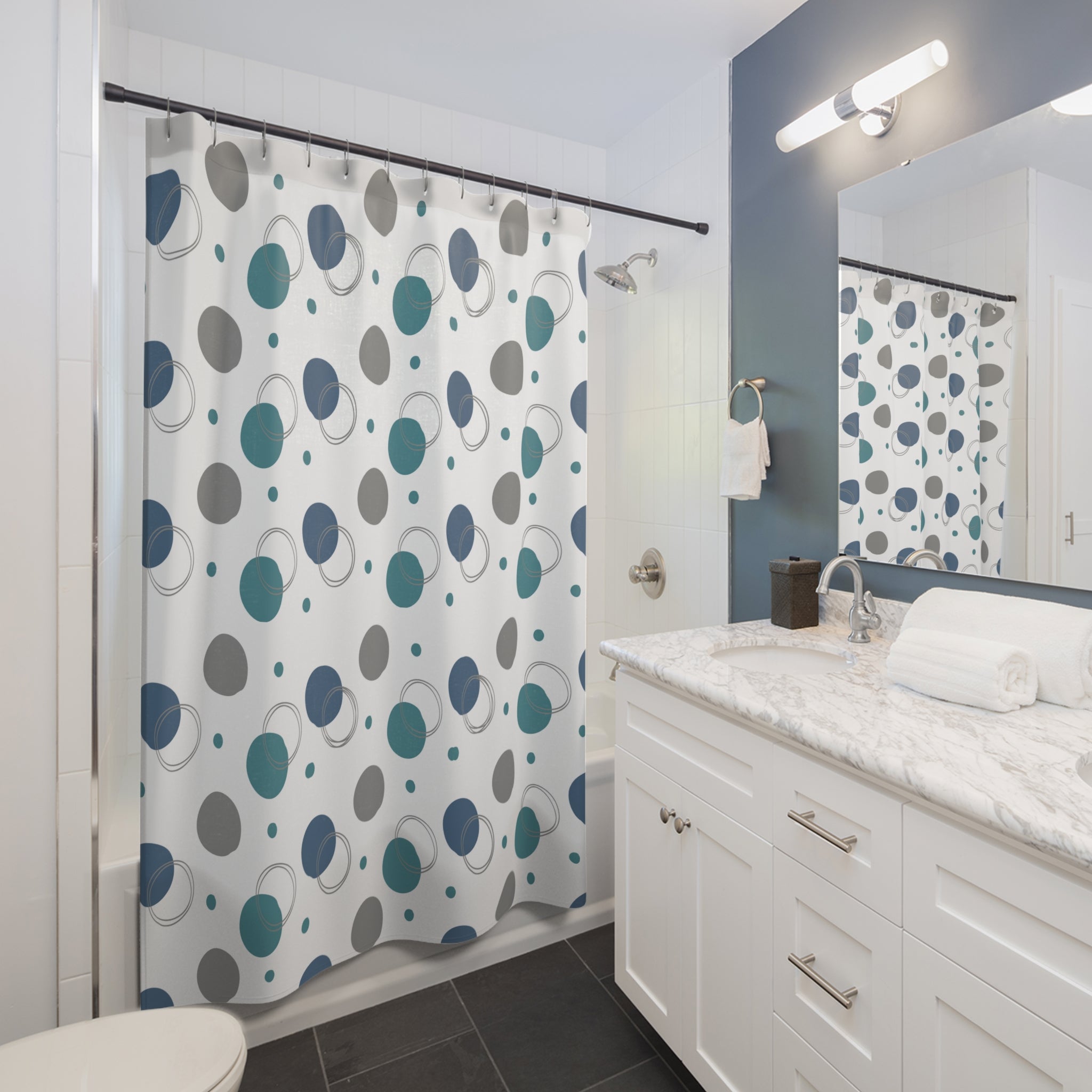 Bathroom with a shower curtain featuring blue and gray circular pattern, white vanity, and mirror.