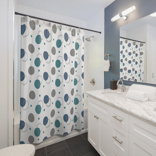 Bathroom with a shower curtain featuring blue and gray circular pattern, white vanity, and mirror.
