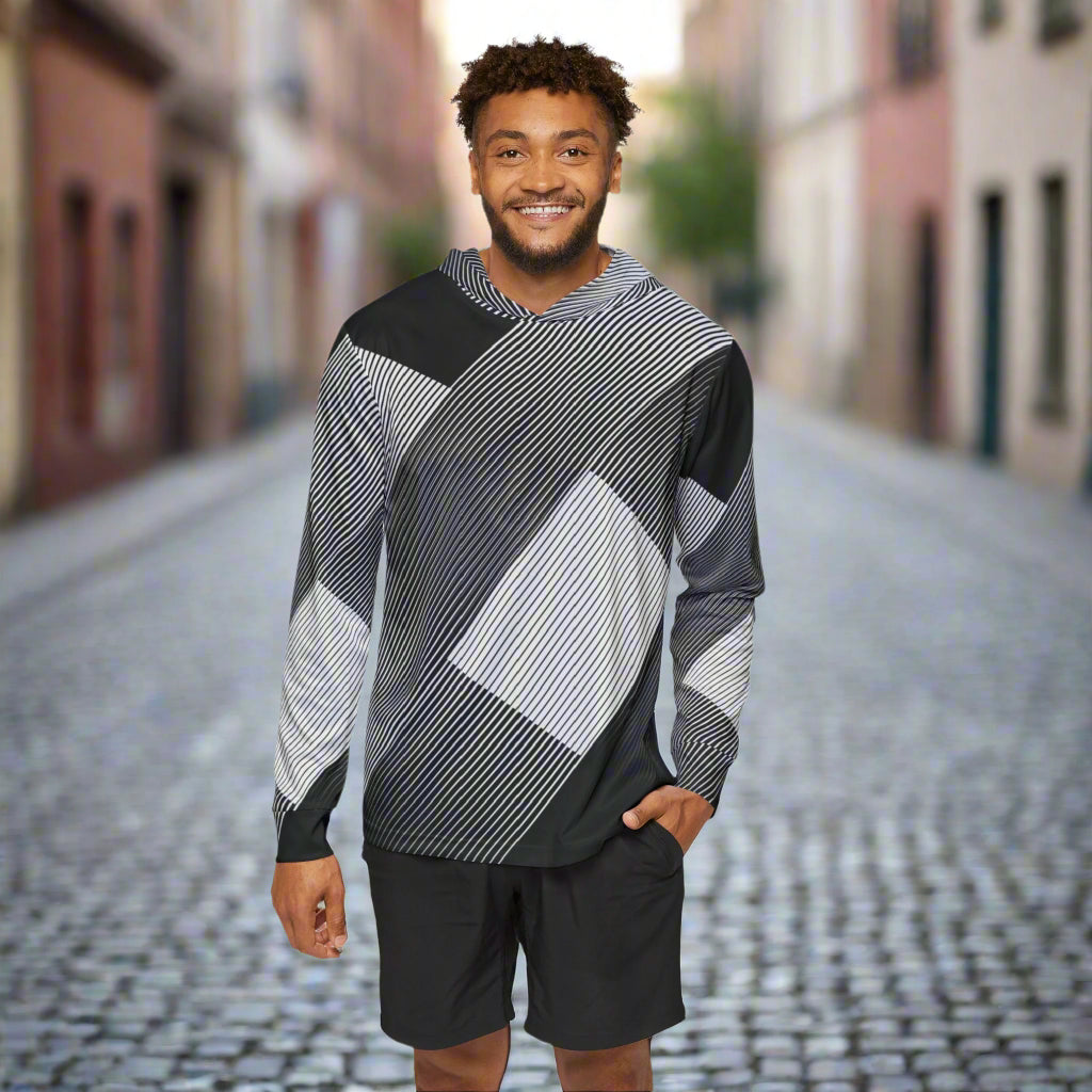 Man wearing a black and gray patterned long-sleeve shirt with black shorts on a white background