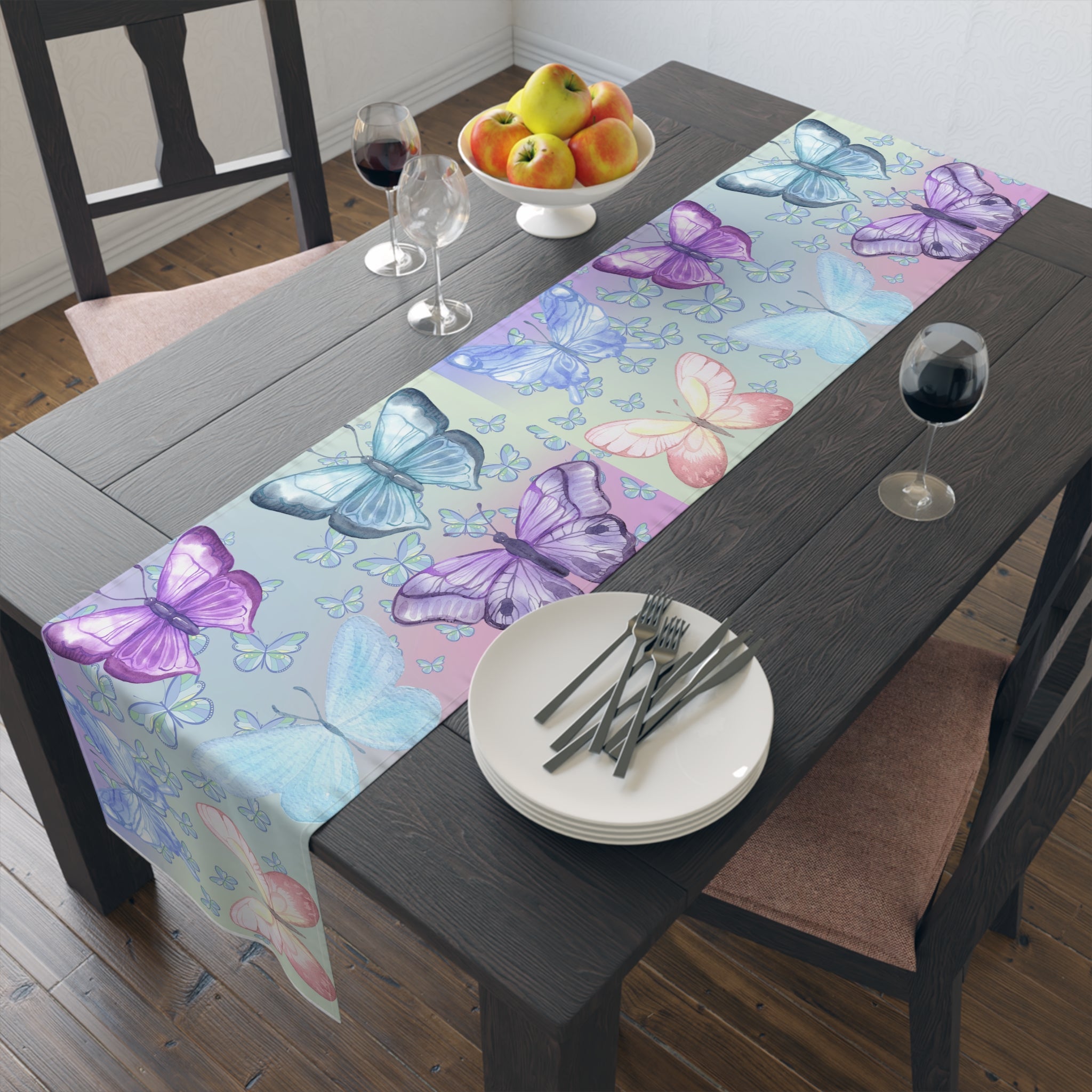 Butterfly patterned table runner on a dining table with fruit and wine glasses.