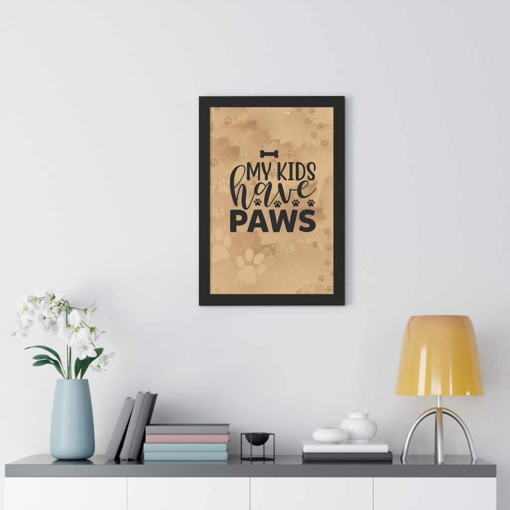 Framed print with 'My kids have paws' text on a wall above a desk with decor items.