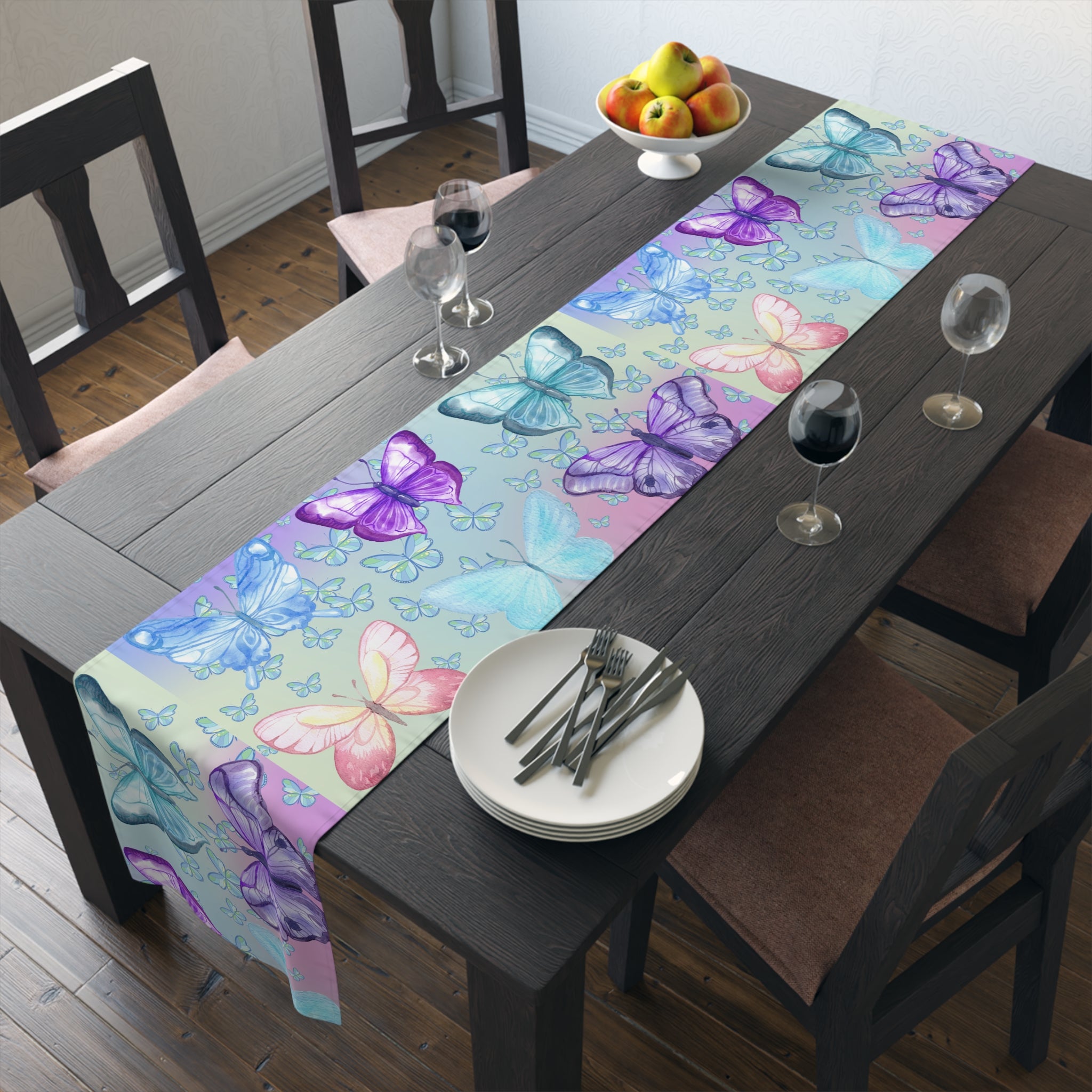 Dining table with a colorful butterfly-patterned table runner, plates, and glasses.