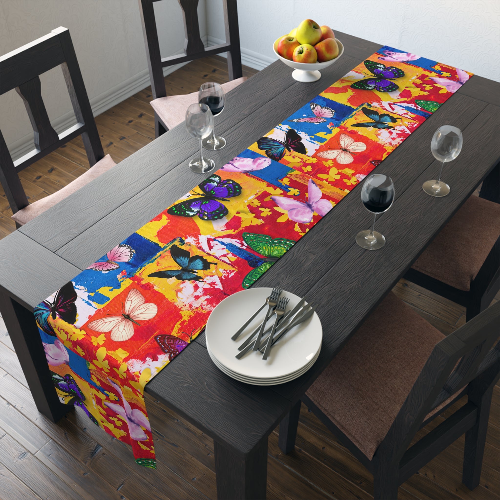 Dining table with a colorful butterfly-patterned table runner, plates, and glasses.