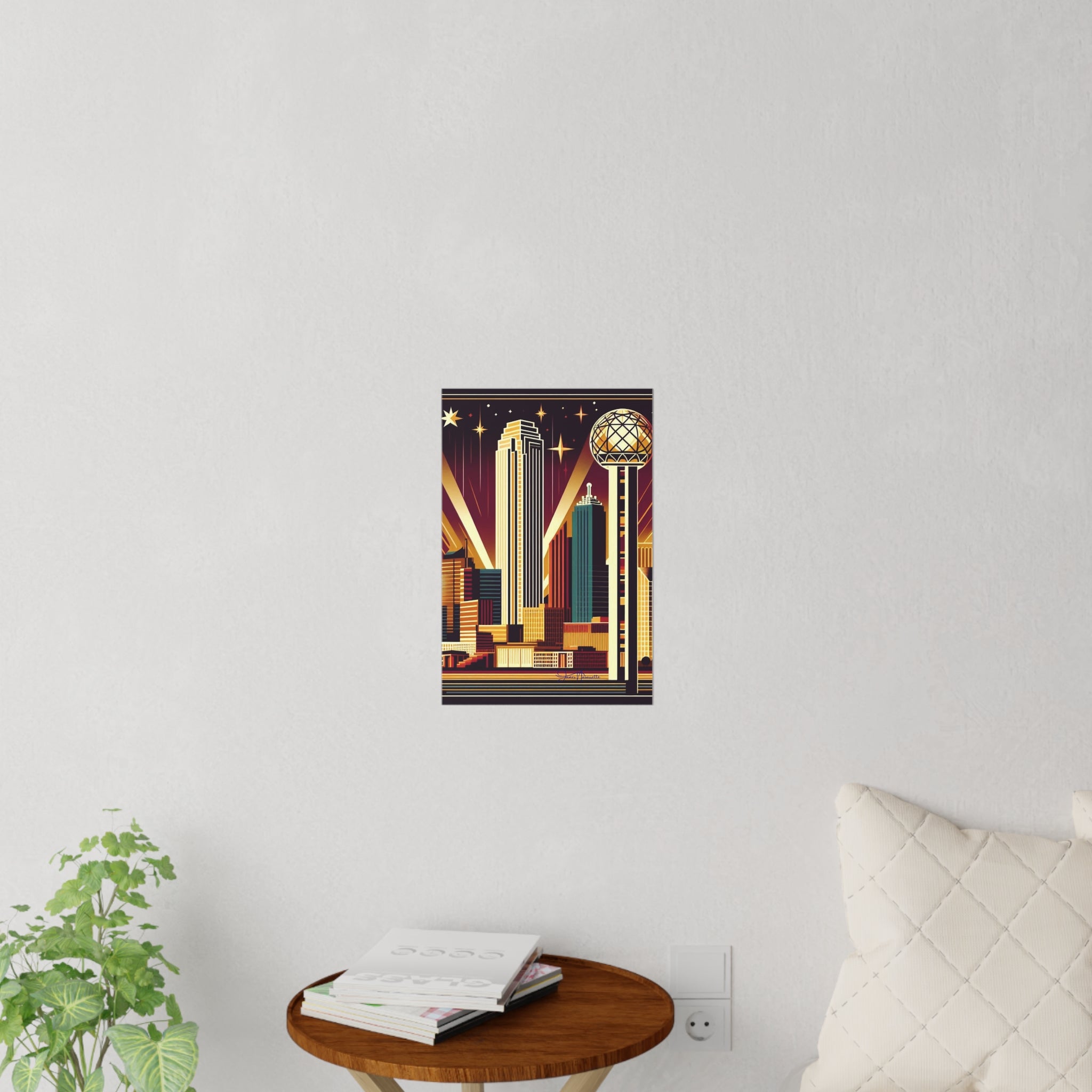 Framed artwork of a cityscape on a wall with a plant and table in the foreground.