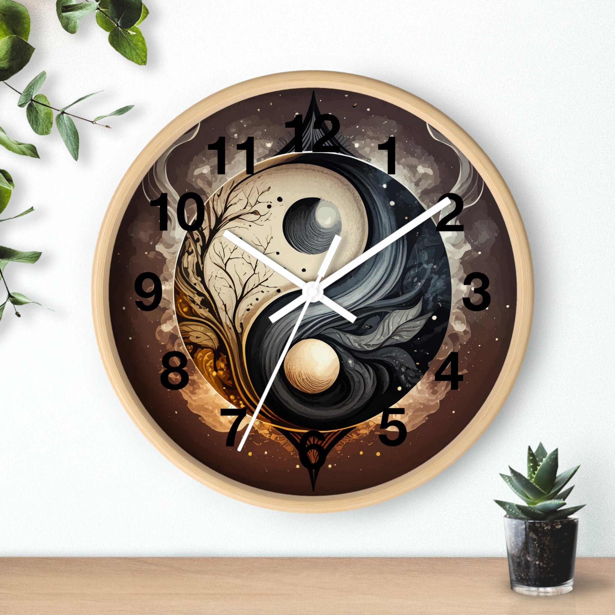 Decorative wall clock with yin yang design on a white wall with a plant and small pot.