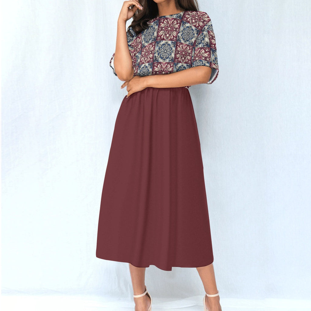 Woman wearing a dress with a patterned top and solid skirt on a white background