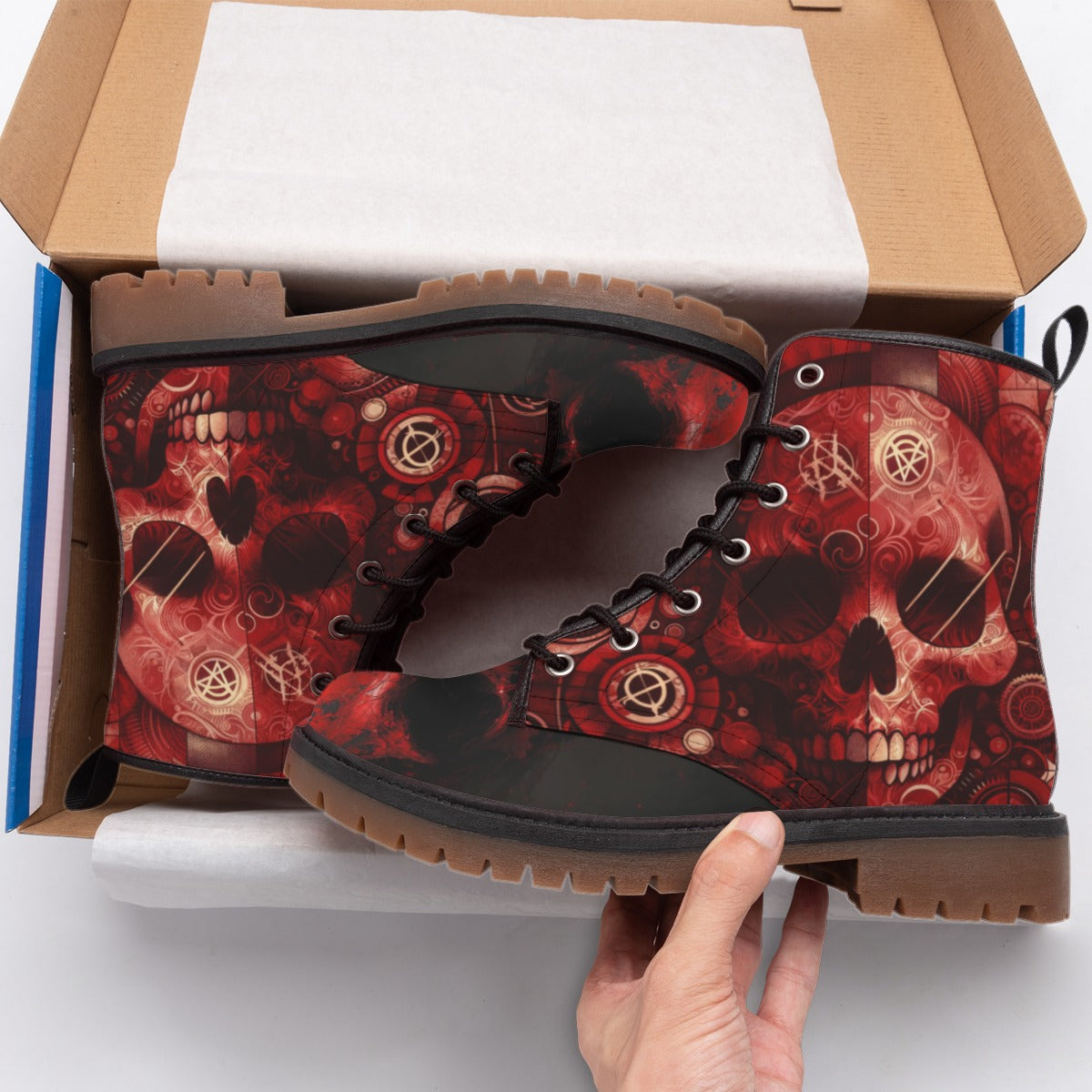 Red skull patterned boots being held above an open box