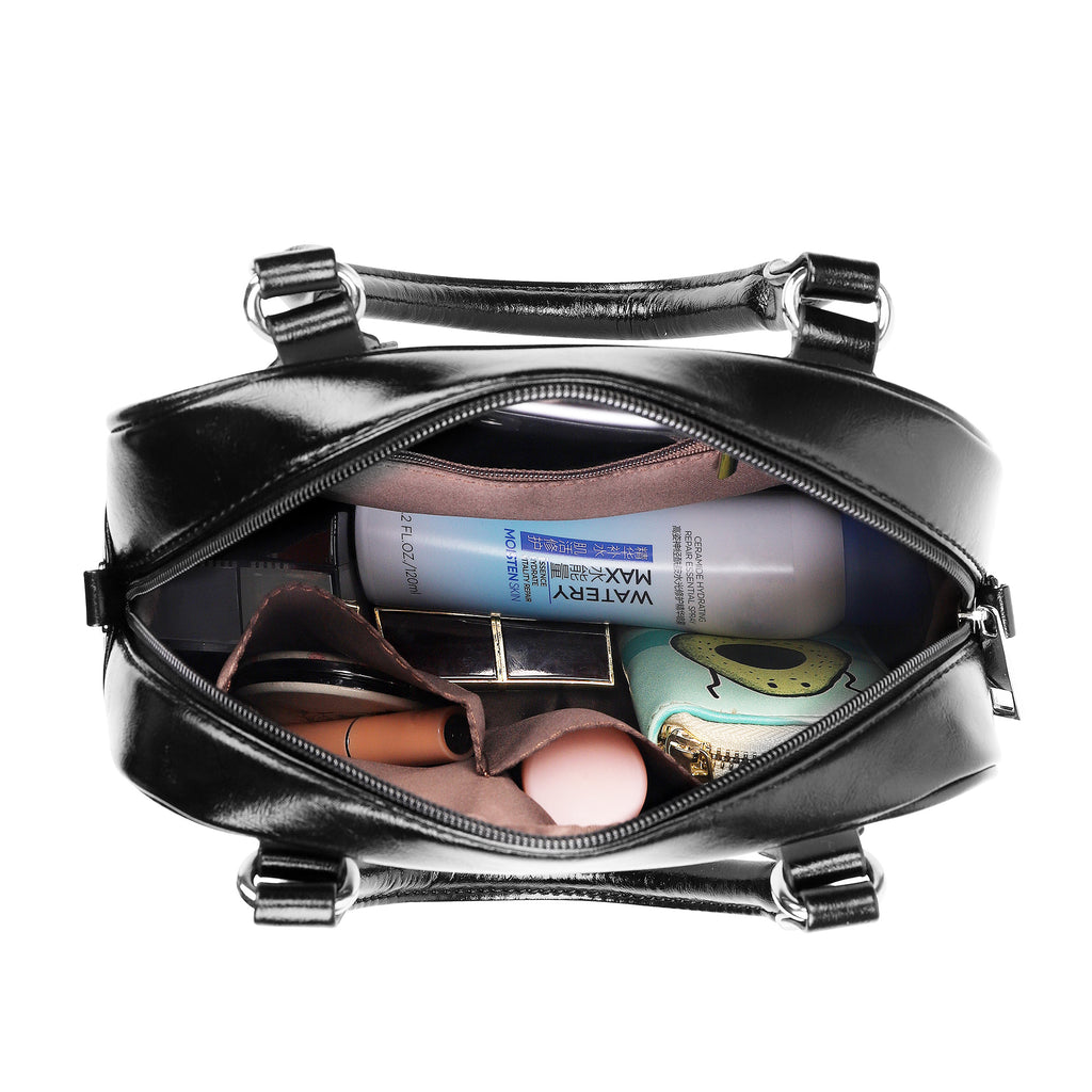 Black handbag with cosmetic items including a bottle of Maybelline and a compact mirror.