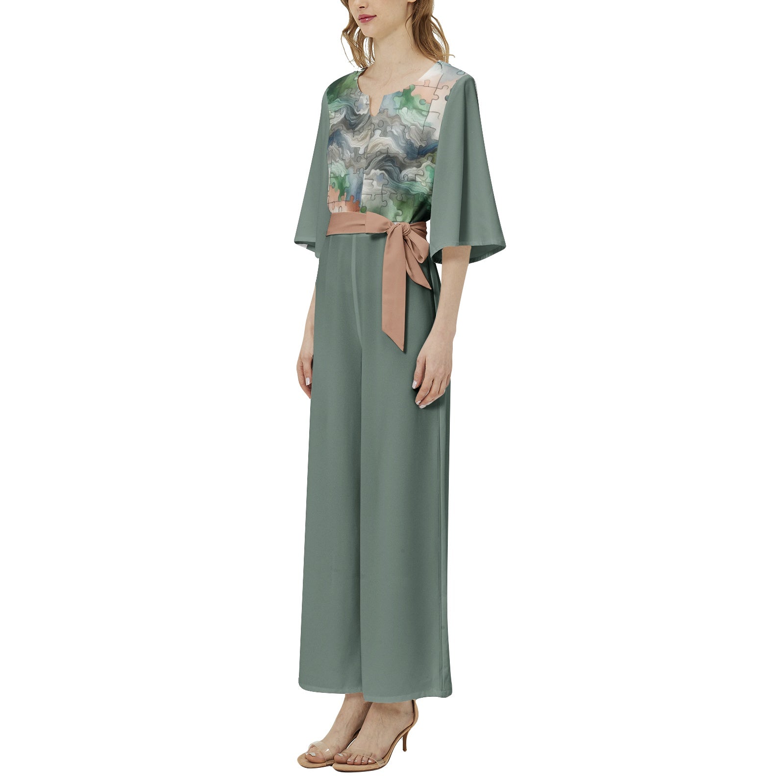 Woman wearing a long green dress with floral patterns on a white background